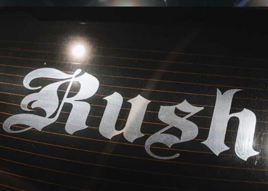 White 'Rush' decal on a black surface